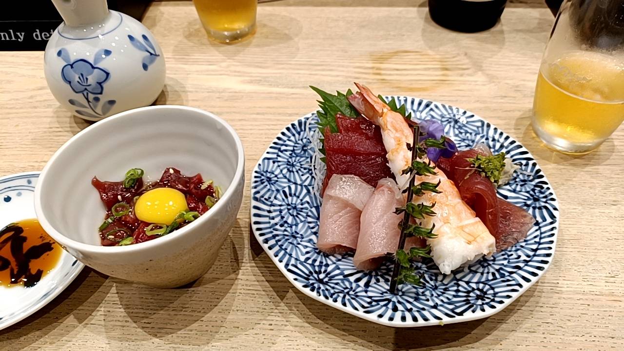 羽田空港の寿司店で提供された日本酒とビール、鮮度の良い刺身盛り合わせの写真。出発前の食体験として印象的な一品。